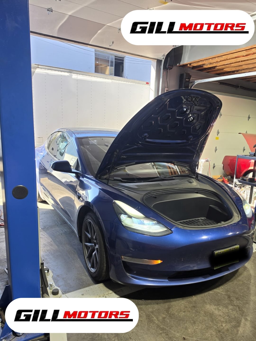 Blue 2021 Tesla Model 3 in the Gill Motors workshop during heat pump repair
